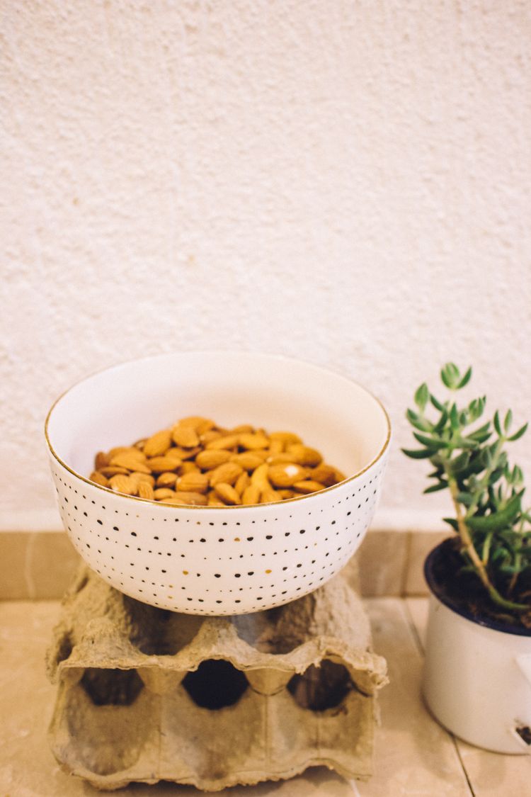 Small white bowl filled with almonds