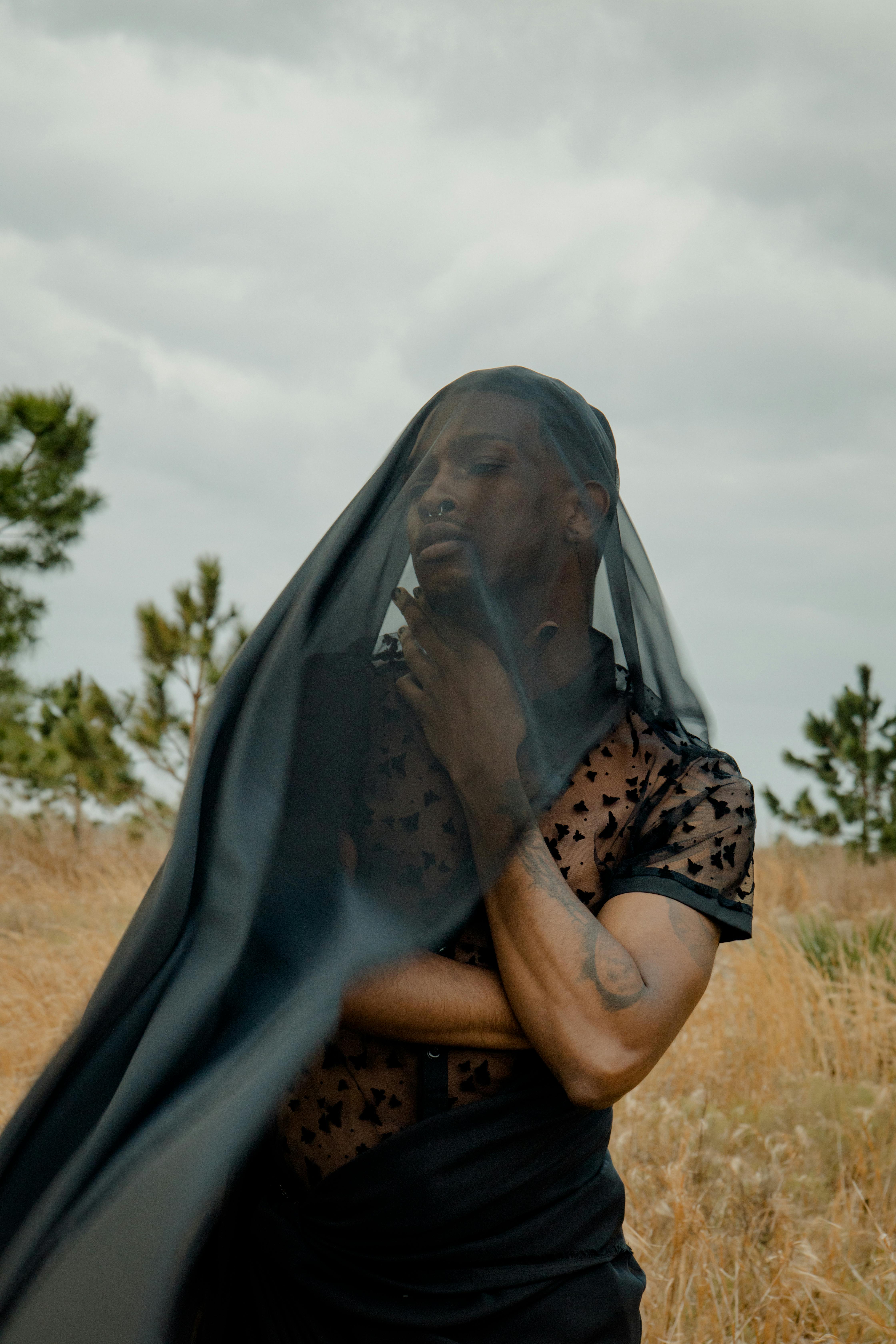 a woman in a veil standing in a field