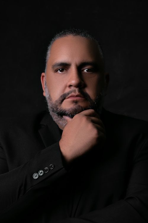 Free Studio portrait of a bearded man with a thoughtful pose against a dark background. Stock Photo
