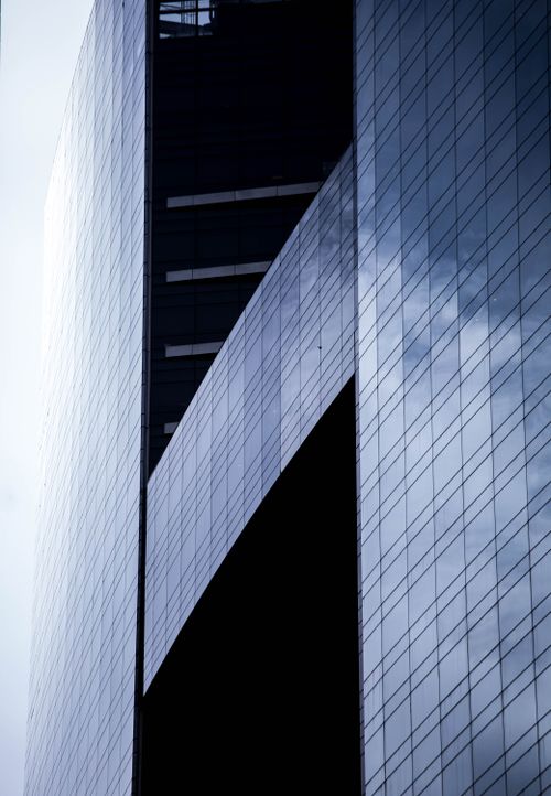 Free A striking view of a modern skyscraper with reflective glass in an urban setting. Stock Photo