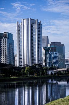 High-rise buildings line a river, reflecting urban architecture.