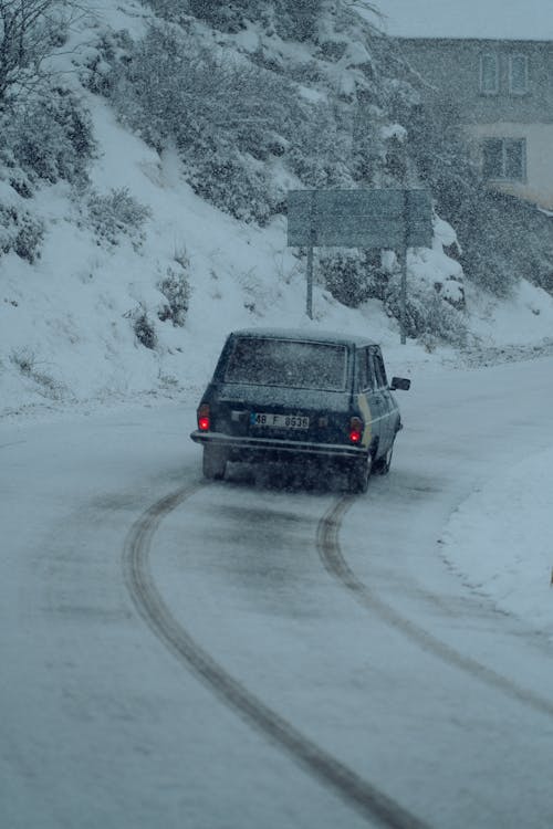 Vintage Car on Road in Snow