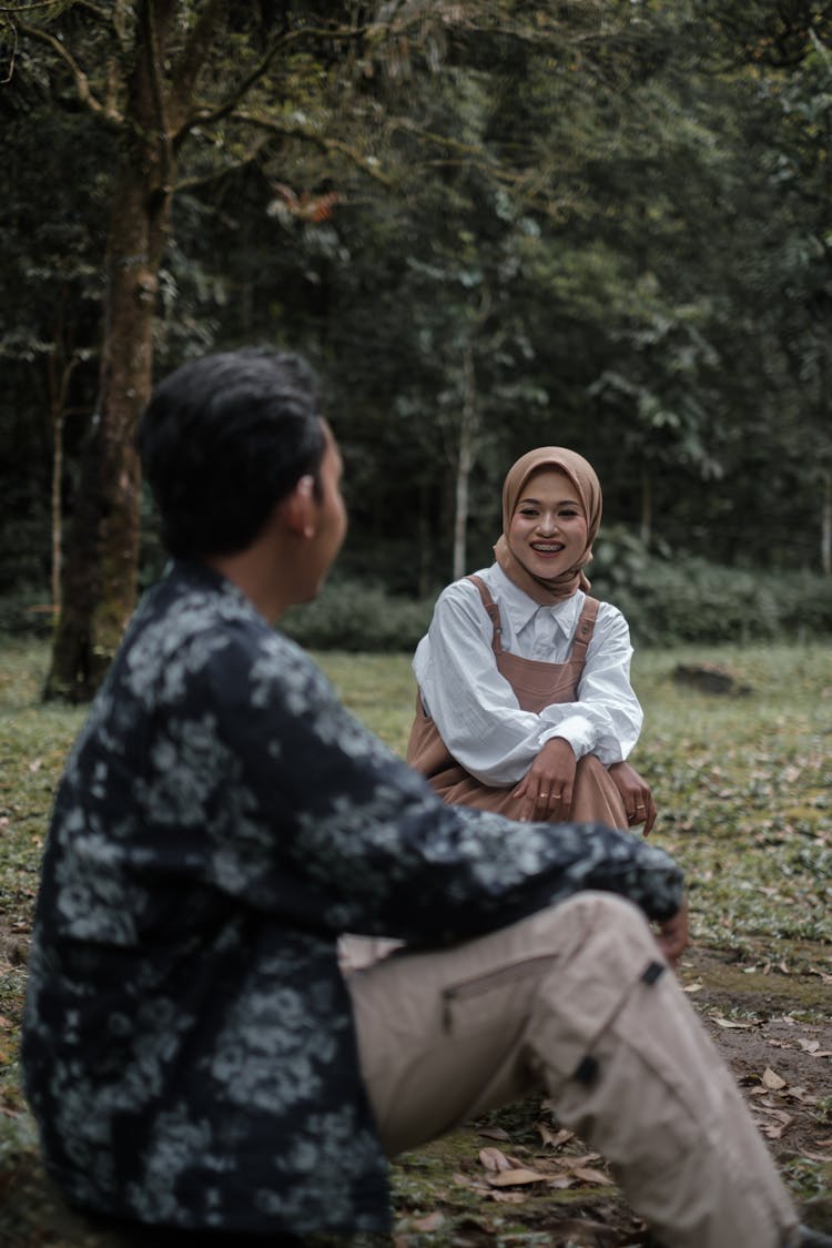 Man And Woman Sitting And Talking In Park