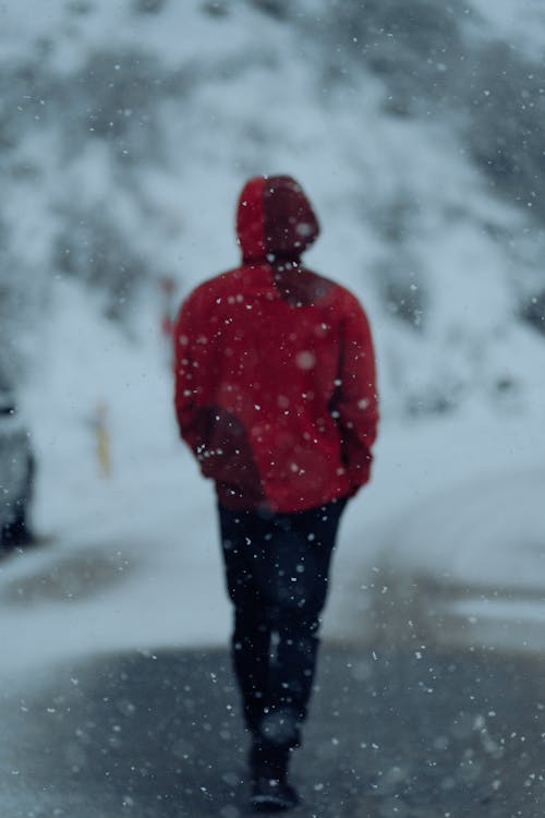 Person in Red Coat Walking through Snowstorm