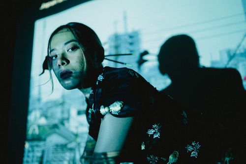 Free Creative portrait of a woman with a cityscape projection casting dramatic shadows. Stock Photo