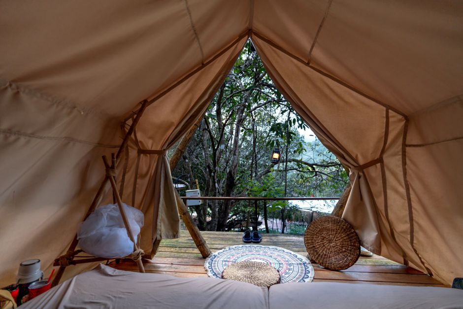 Experience tranquility in a cozy tent overlooking a serene forest setting. Experience tranquility in a cozy tent overlooking a serene forest setting.