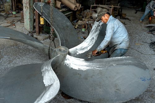 Man Grinding Propeller in Workshop