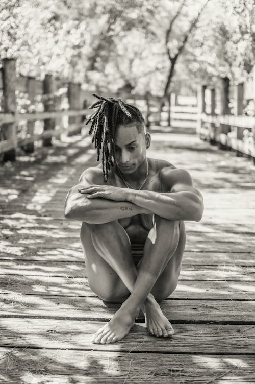 Man Sitting on Wooden Path 