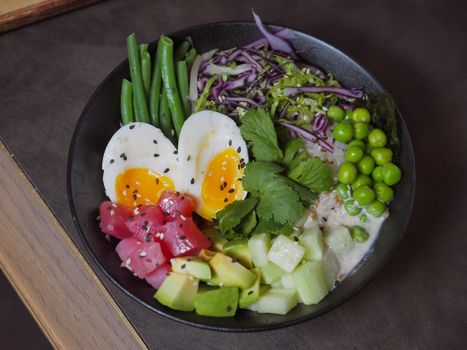 A delicious and colorful poke bowl featuring eggs, vegetables, and fresh produce, perfect for a healthy meal.