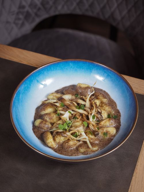 Free Delicious gnocchi in a rich mushroom sauce served in a vibrant blue bowl. Stock Photo
