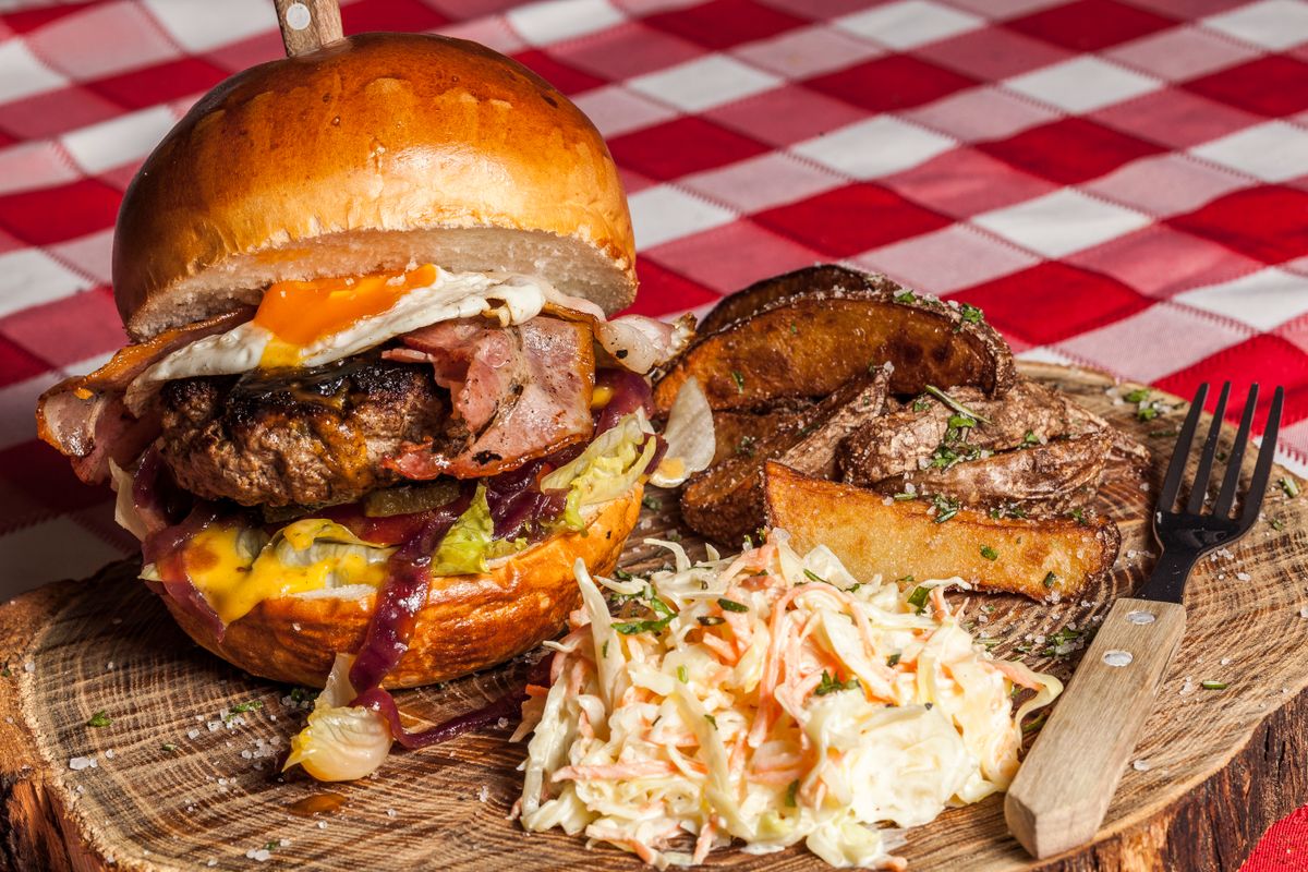 Juicy diner cheeseburger with crispy bacon and fresh coleslaw side