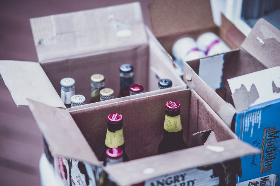 Variety of beer bottles displayed in open cardboard boxes.