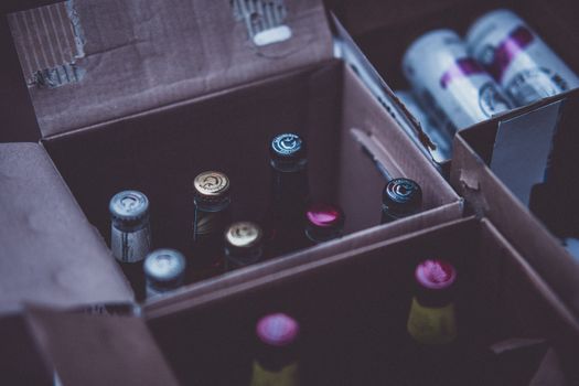 Photo by Craig Adderley Close-up of various alcohol bottles and cans in cardboard boxes indoors.