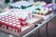 Selective Focus Photography of Red Coca-cola Can Lot on Box