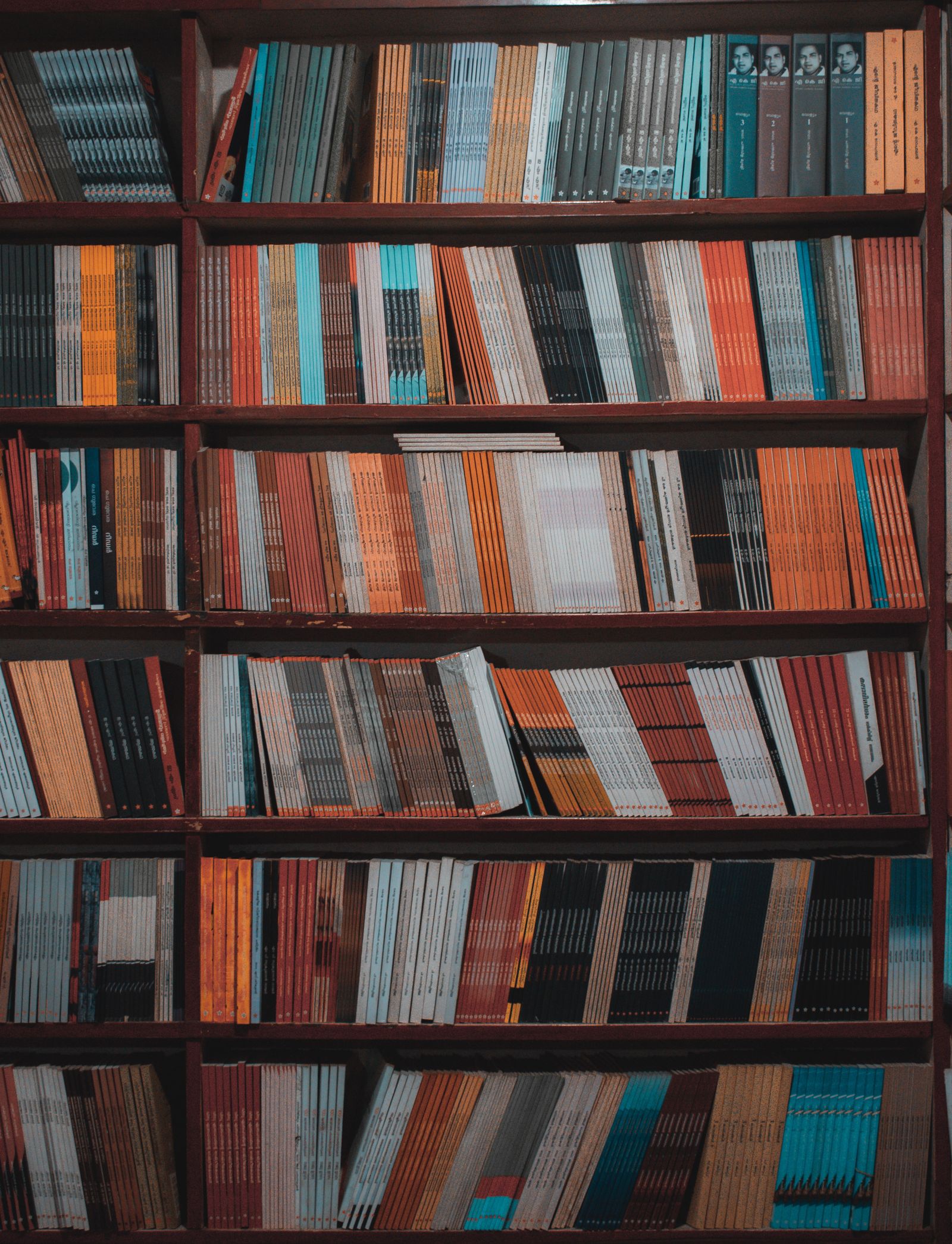 A tall library bookcase densely packed with colorful book spines