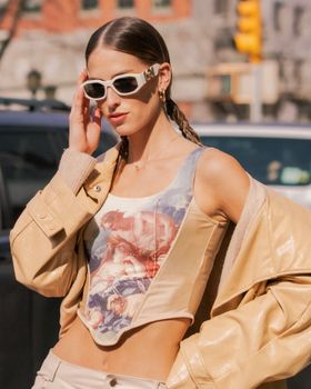 Fashionable woman in sunglasses posing on a sunny New York street.