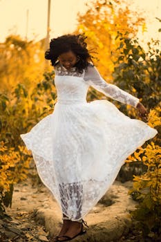 一名女子身着美丽的白色连衣裙，置身于生机勃勃的秋叶之中，散发着幸福与优雅