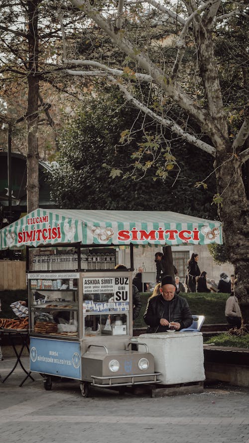 Man Sitting by Street Food Stall