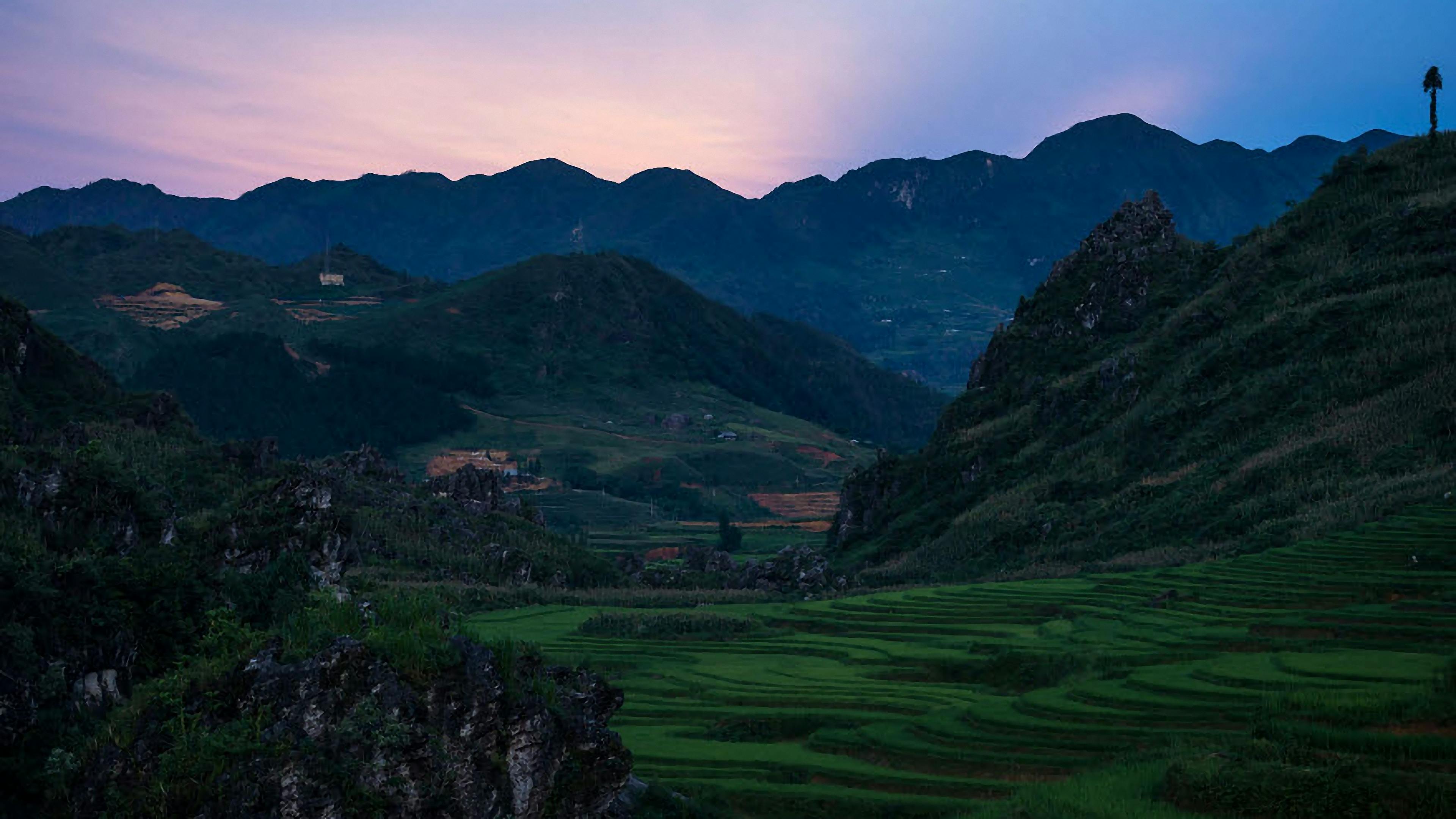 越南嘉莱县雅在暮光中呈现宁静的稻田与山脉景色
