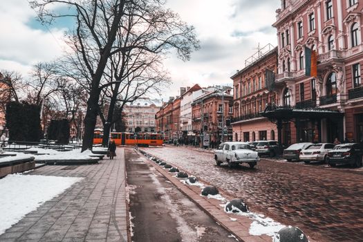 Charming winter cityscape of Lviv with snow-covered cobblestone streets and historical buildings.