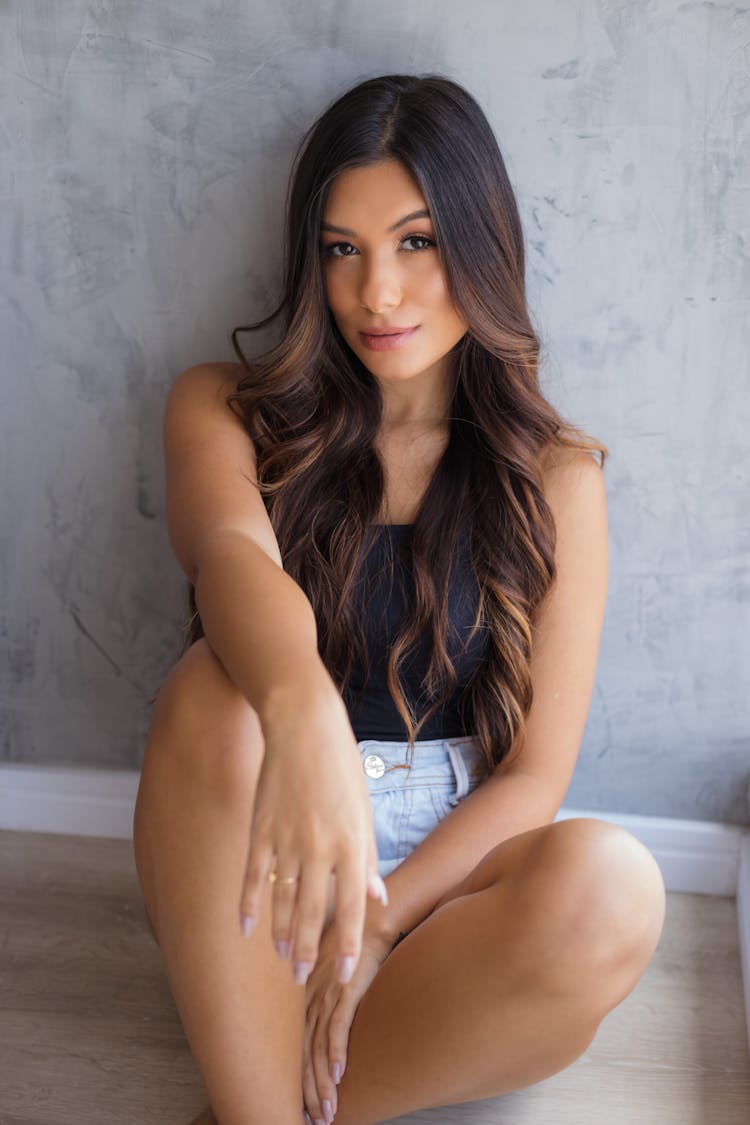 Brunette Woman Sitting By Wall