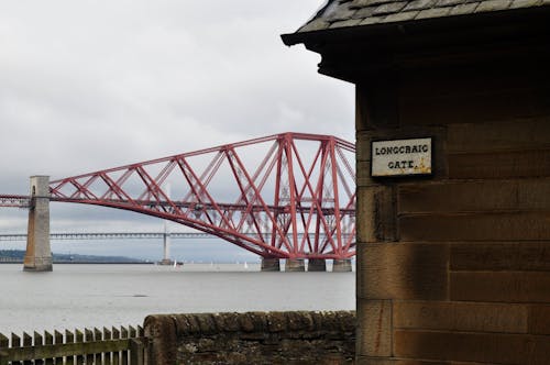 Photo of the Forth Bridge in Scotland with a Building in the Foreground