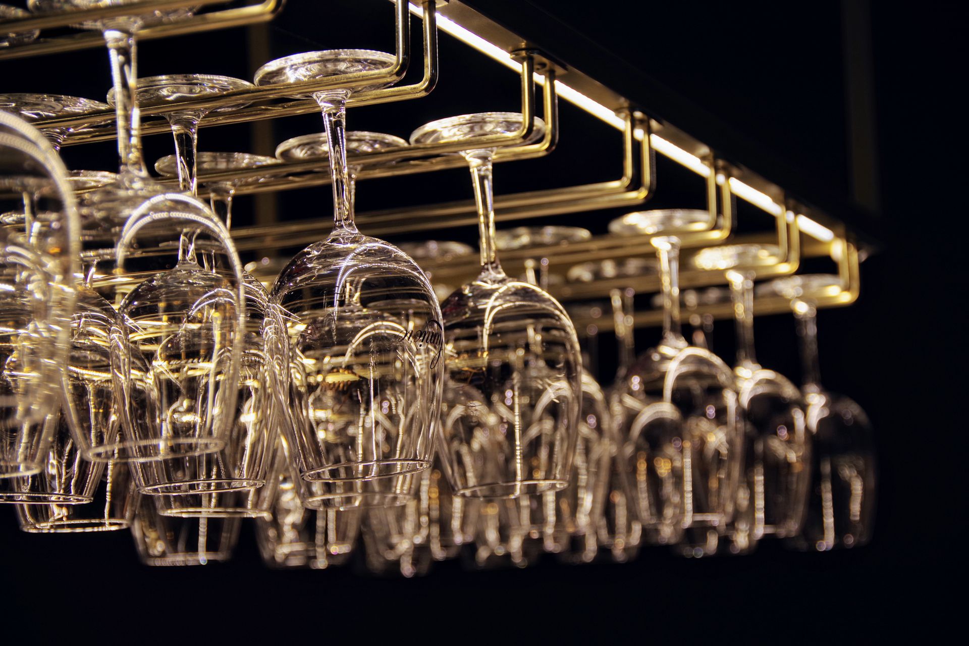 Set of elegant glasses hanging on metal rack