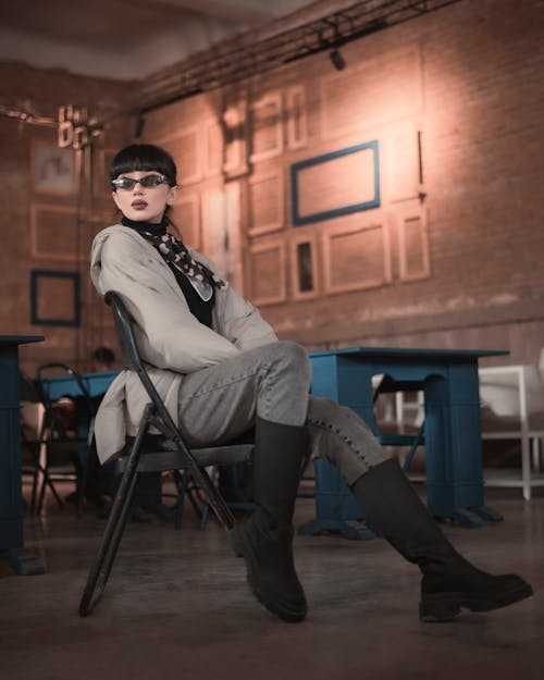 Young Fashionable Woman Wearing Sunglasses Sitting on a Chair 