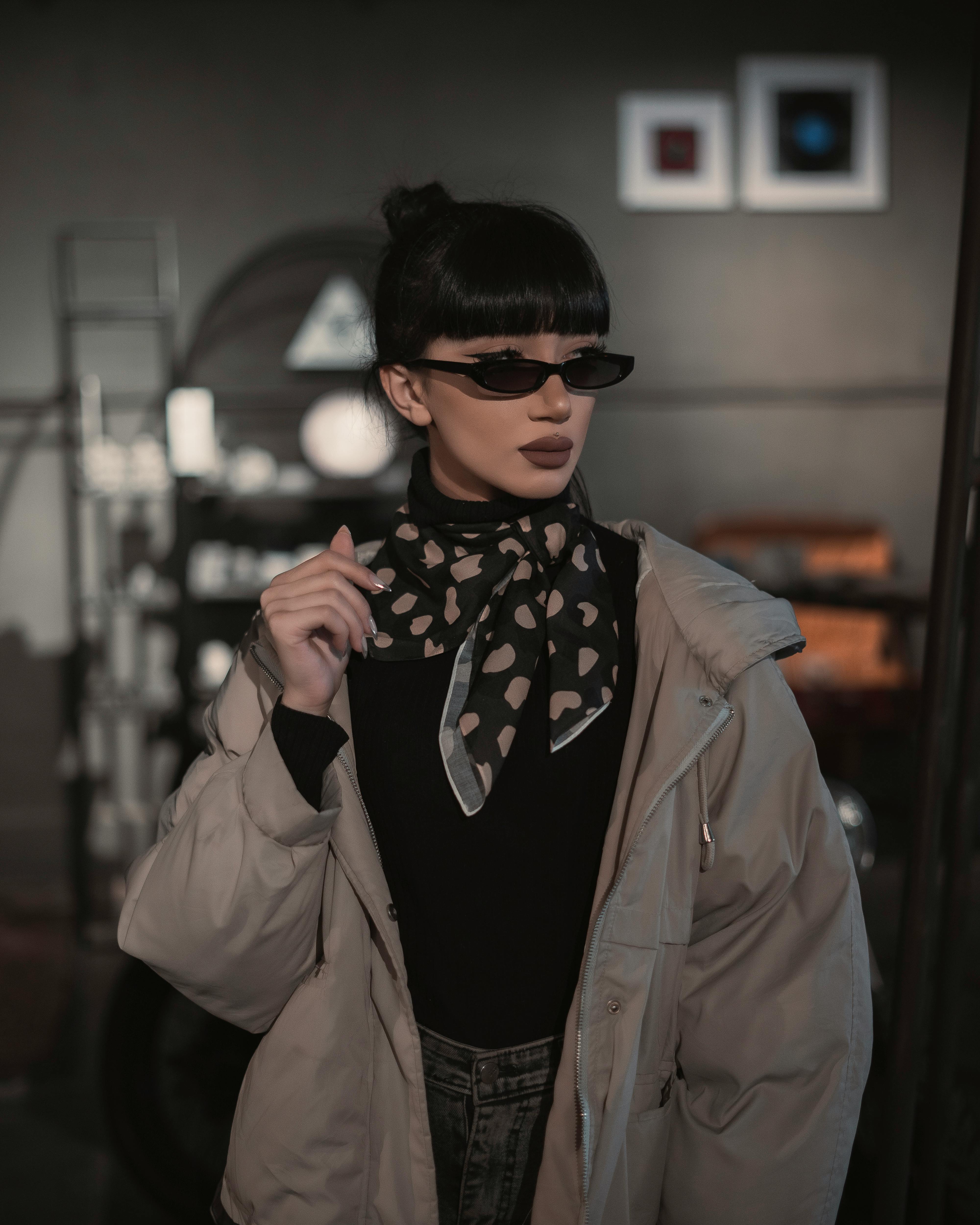 Trendy woman with sunglasses and scarf posing indoors in Iran.