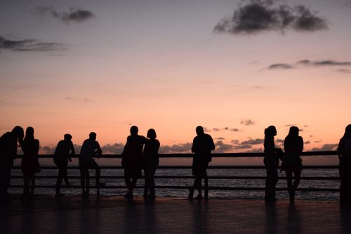 Free Silhouetted people on a Batumi seaside promenade at sunset, creating a serene and picturesque scene. Stock Photo