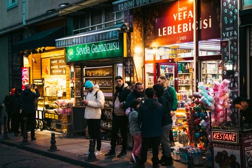 Free Nighttime street scene in Istanbul with shops, people, and vibrant lights. Stock Photo