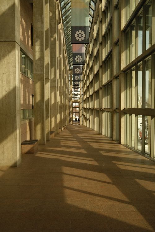 Free A sunlit corridor with a modern architectural design and symmetrical window reflections, captured indoors. Stock Photo