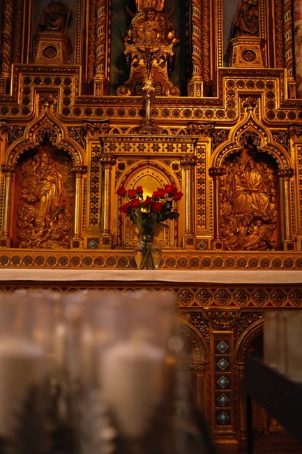 Fotomural Intricado altar dorado con detalles ornamentales en un entorno histórico de iglesia católica, con velas.