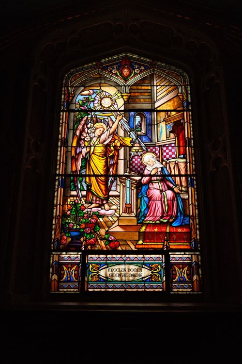 Free Intricate stained glass window depicting a religious scene inside a historic church. Stock Photo