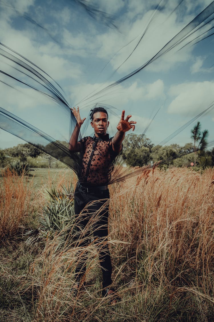 Standing Man Holding Transparent Black Fabric