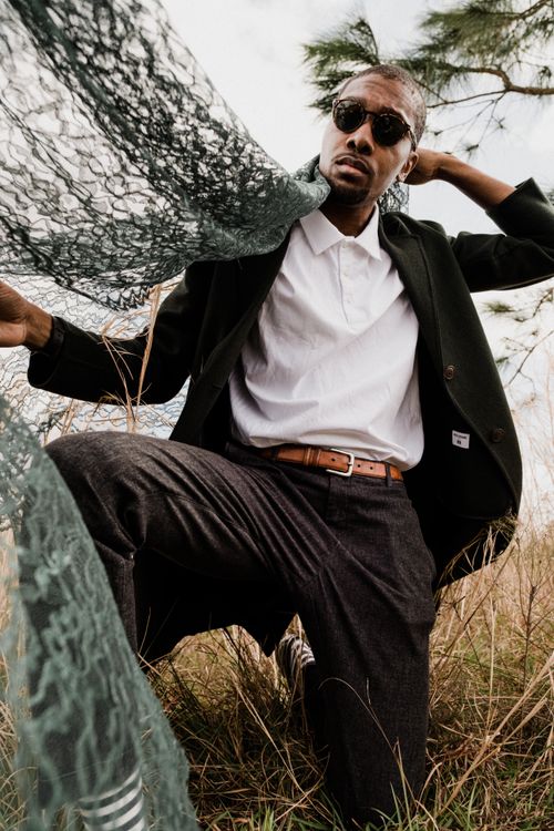 Free Stylish man posing outdoors with fabric for fashion photography. Stock Photo