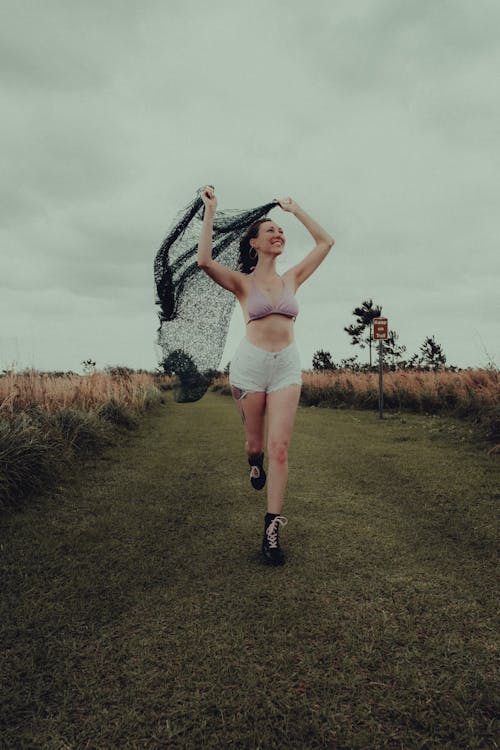 Free Smiling Woman in a Pink Bra Walking Down a Field Stock Photo