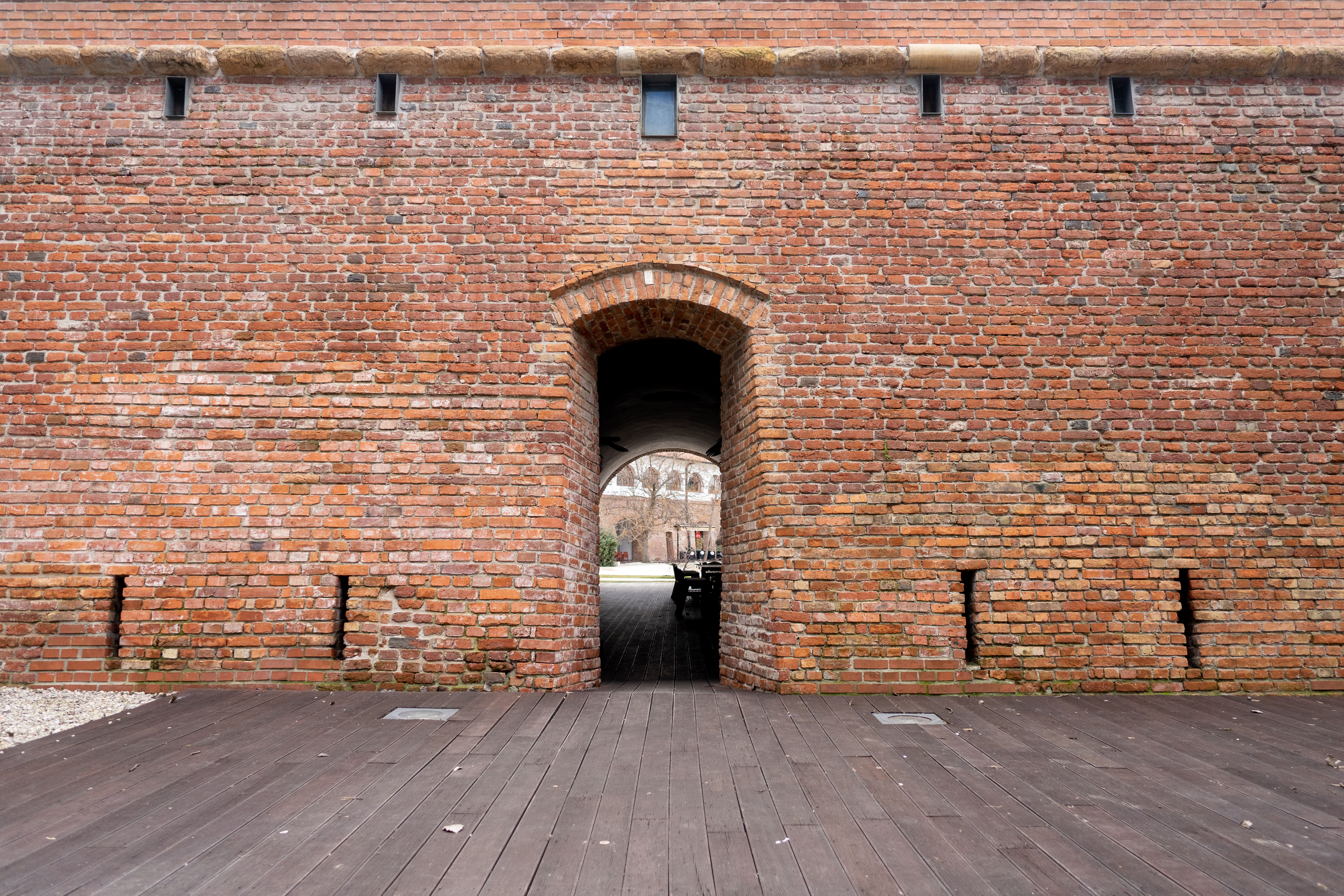Explore the medieval brick wall and entrance at a historic fortification in Timisoara, Romania.