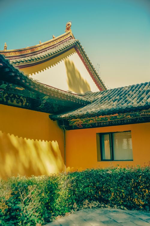 Free Vibrant traditional Chinese roof architecture highlighted against yellow walls in an outdoor setting. Stock Photo
