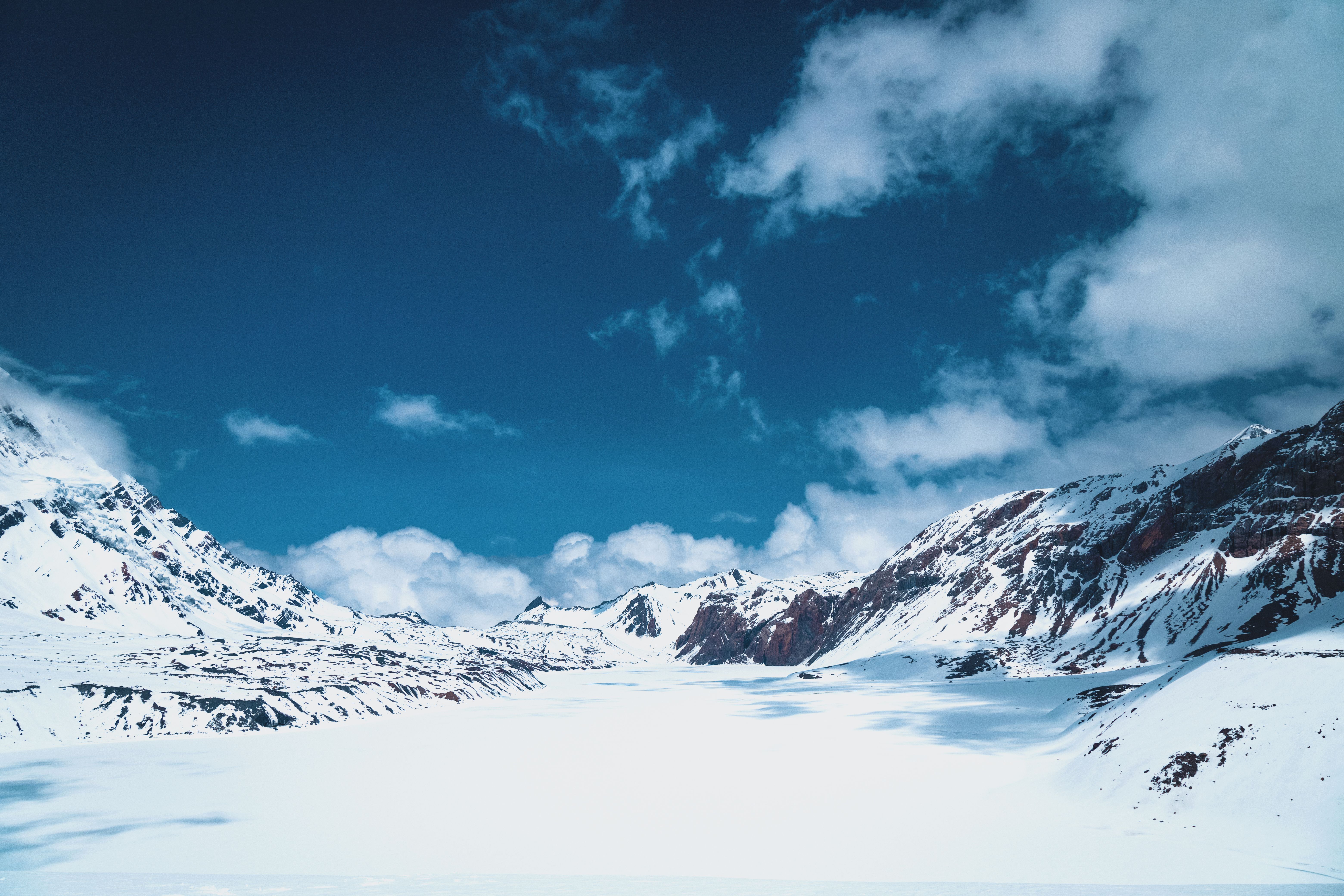A snowy mountain range with a blue sky · Free Stock Photo
