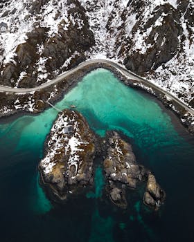 挪威特罗姆斯白雪皑皑的沿海道路与碧绿海水，构成了一幅令人惊叹的鸟瞰图景