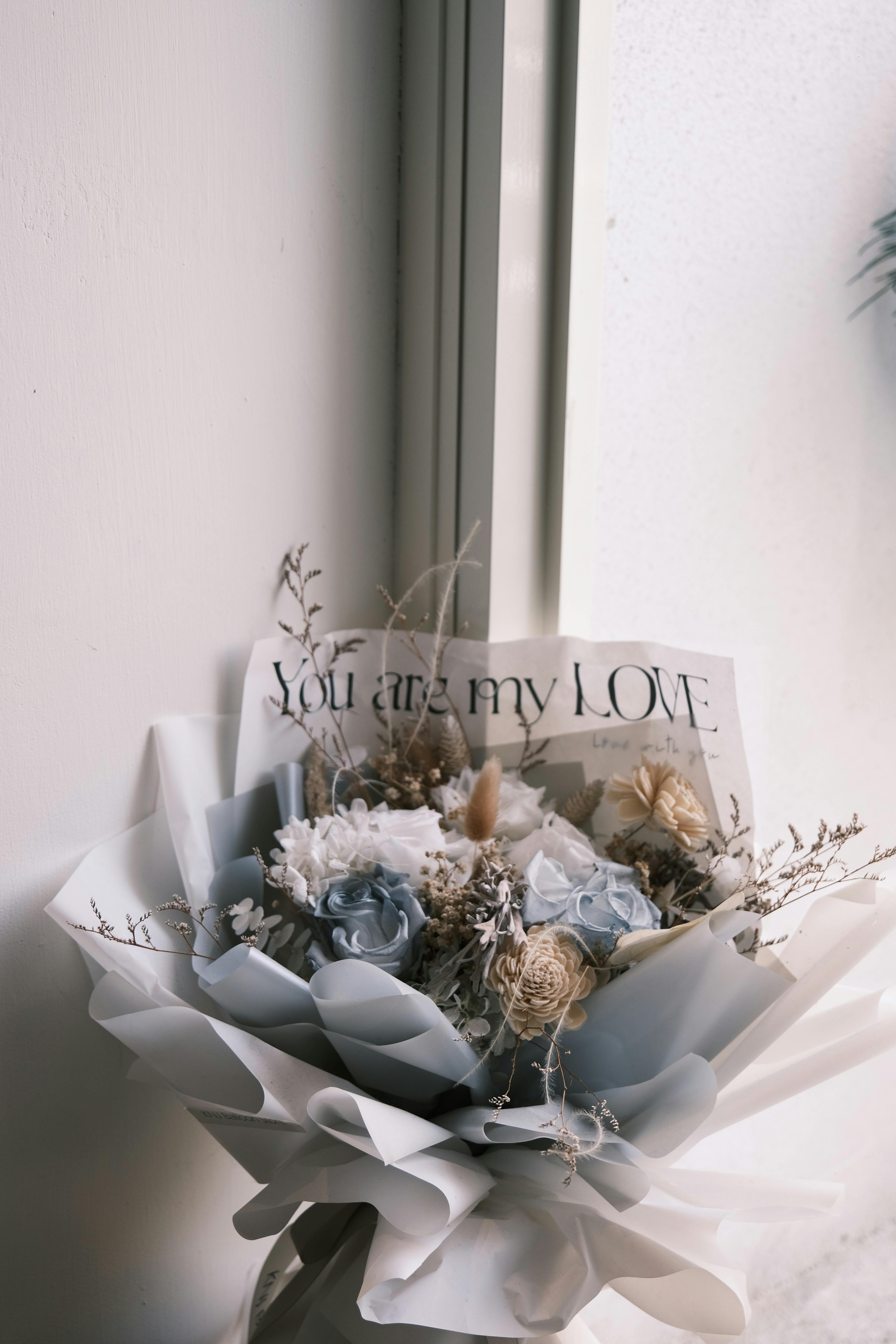 A sophisticated bouquet of white and pale blue flowers with a heartfelt note.