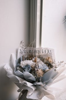 A sophisticated bouquet of white and pale blue flowers with a heartfelt note.