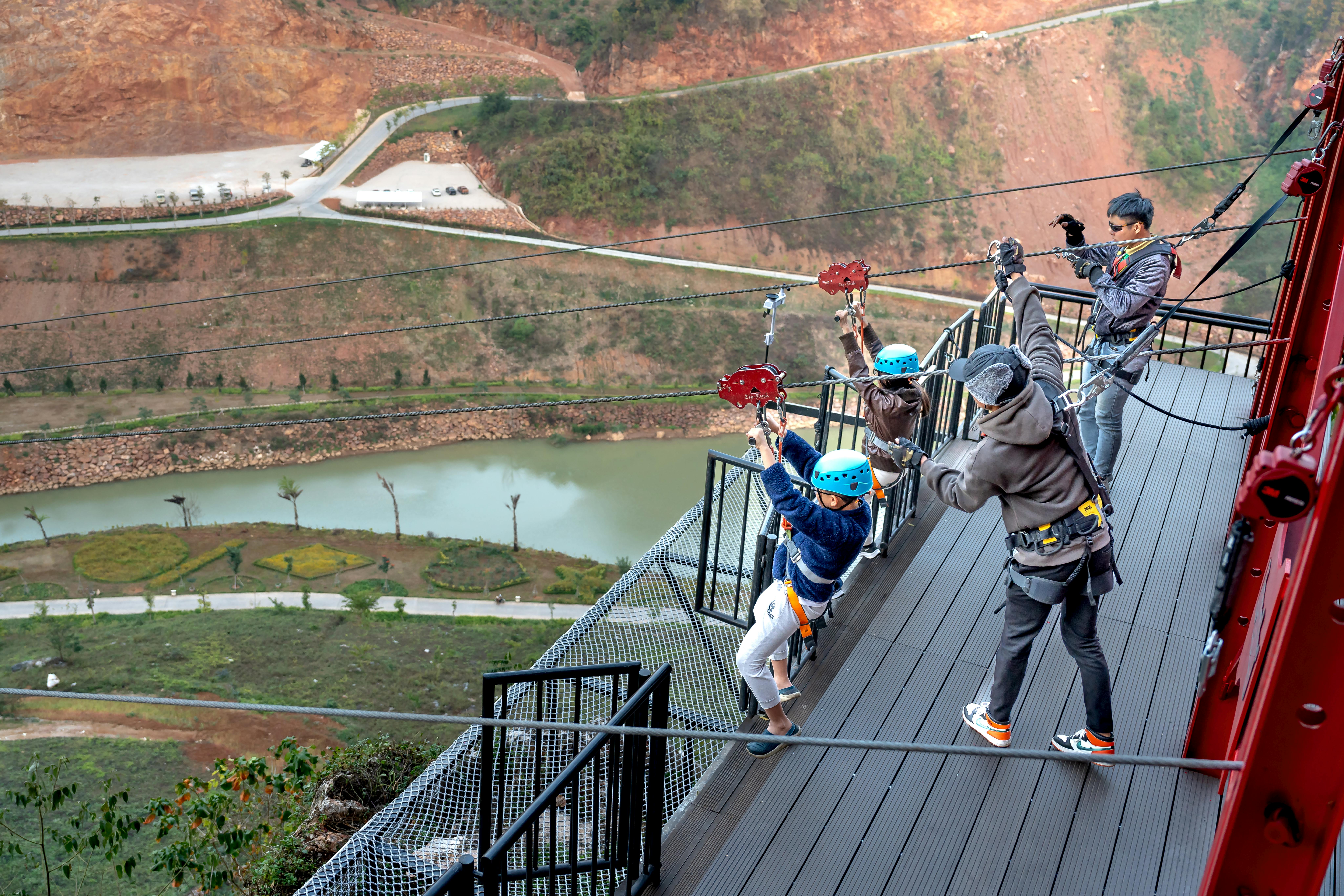 Children zipping across a breathtaking river gorge, capturing the thrill of outdoor adventure.