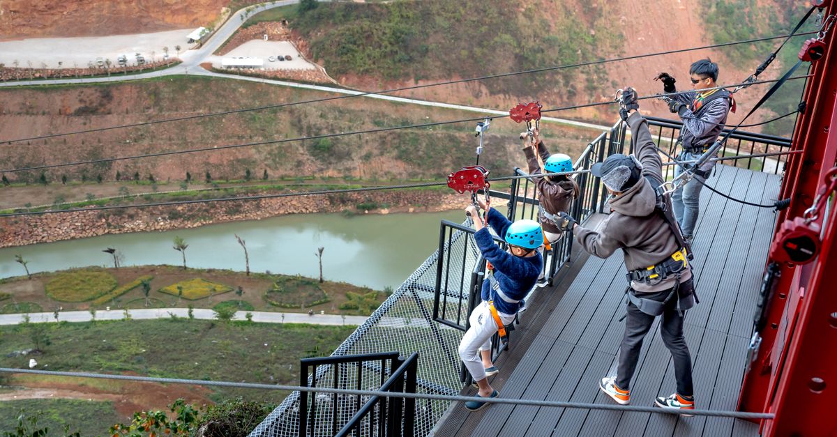 Children zipping across a breathtaking river gorge, capturing the thrill of outdoor adventure.