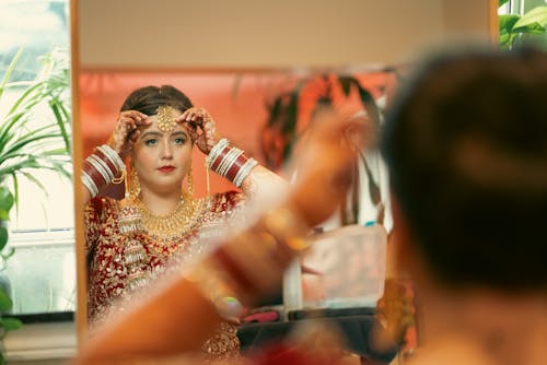 Bride Trying on Jewellery in Mirror
