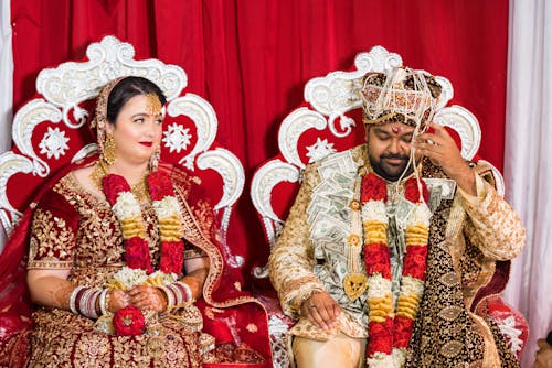 Couple in Costumes Sitting on Chairs 