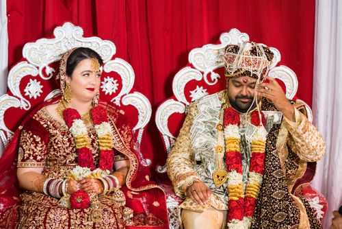 Free Beautiful Indian couple in traditional attire during a vibrant wedding ceremony indoors. Stock Photo
