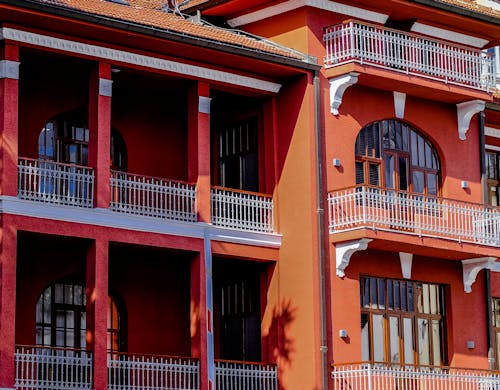 Facade of a Red Building with Balconies and Windows with Wooden Frames