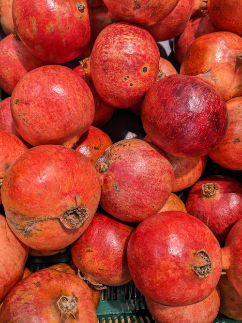 Free A close-up view of ripe, fresh pomegranates displays vibrant red hues under the warm autumn sun. Stock Photo
